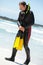 Male diver with diving suit snorkel mask fins on the beach