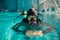 Male diver in scuba gear and mask poses in pool