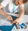 Male DIY-designer transfers a template to fabric in a home studio.A self-taught seamster in white t-shirt and glasses works with