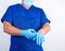 male doctor in blue uniform puts on his hands blue sterile latex gloves before surgery