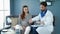 Male doctor checking pulse with wrist watch on pregnant woman hand.