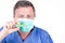 Male doctor chemist hand in protective gloves blue mask hold test green coronavirus tube