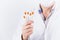 Male doctor endocrinologist in mask holding five insulin syringes on white background