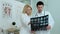 Male doctor and female colleague examining patient chest x-ray film lungs scan at radiology department in hospital