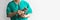 Male doctor in green costume holds in hands and examins with stethoscope grey toy cat on white background. Horizontal