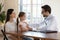 Male doctor holding hand on little cute patient shoulder.