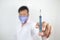 A male doctor holding a syringe and needle with selective focus on syringe.test your blood for corona virus concept