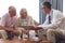 Male doctor interacting with senior couple at retirement home