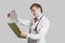 Male doctor in a lab coat reading medical records over gray background