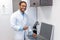 Male doctor in lab coat standing the box with optometric equipment