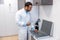 Male doctor in lab coat standing the box with optometric equipment