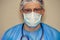 Male doctor in mask, glasses and stethoscope looking at the camera. Tired medical worker doctor after taking a large number of pat