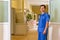 Male doctor in scrubs standing in a hospital and welcoming patients for vaccination