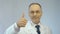 Male doctor smiling at camera, making thumbs-up hand sign, best medical aid