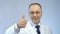 Male doctor smiling at camera, making thumbs-up hand sign, best medical aid