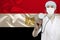 Male doctor with a stethoscope against the background of the silk national flag of Egypt, concept of national medical care, health