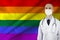 Male doctor with a stethoscope against a silk LGBT rainbow flag, Pride flag, concept of national medical care, health, insurance,