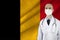 Male doctor with stethoscope on the background of the silk national flag of Belgium, concept of national medical care, health,