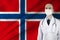 Male doctor with stethoscope on the background of the silk national flag of Norway, concept of national medical care, health,