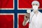 Male doctor with stethoscope on the background of the silk national flag of Norway, concept of national medical care, health,