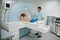 Male doctor turns on magnetic resonance imaging machine with patient inside