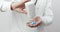 Male doctor in uniform pouring pills out of bottle