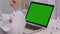 Male doctor uses a laptop with a green screen chroma key for work and typing. Telemedicine, telehealth concept. Remote