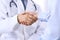 Male doctor and woman patient shaking hands. Partnership in medicine, trust and medical ethics concept