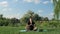 Male doing yoga outdoors on mat. Young tranquil man sitting in lotus position and meditating in morning on grass. Person practicin