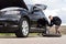 Male driver changing his tyre at the roadside