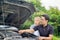 A male driver checks the condition of a car after an accident with an engine