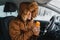 Male driver warms up with a hot drink from a thermos while his car stalled somewhere in the winter mountains