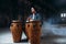 Male drummer plays on wooden drums in factory shop