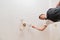 A male electrician changes the light bulbs in the ceiling light.