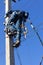 A male electrician climbs up a reinforced concrete pillar for mounting a line of electrical wires