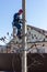 A male electrician climbs up a reinforced concrete pole to install electrical wires