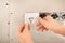 Male electrician repairing socket in flat, closeup