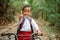a male elementary student riding his bike through the country road with thumb up