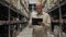 A male employee checks the stocks in the retail warehouse of shelves with goods