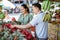 male employee helping the customer choosing the dragon fruits