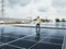 Male engineer checks a photovoltaic solar plant and uses a recording tablet. mechanic in protective helmet. Man in uniform