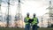 Male engineers look at power poles in the field.