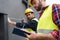 male engineers in safety vests and helmets working with measuring tape and clipboard