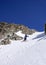 Male extreme skier skiing down a very steep couloir in deep winter in the Swiss Alps near Klosters