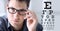 Male face with spectacles on eyesight test chart background