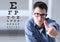 male face with spectacles on eyesight test chart background, showing like hand, eye examination ophthalmology concept