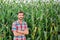 Male farmer checking plants on his farm. Agribusiness concept, agricultural engineer standing in a corn field with a tablet,