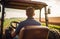 male farmer drives tractor through wheat field at sunset, harvest season, agricultural concept