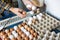 Male farmer hands packing eggs from conveyor belt into cardboard tray