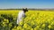 Male Farmer in Oilseed Rapeseed Cultivated Agricultural Field Examining and Controlling The Growth of Plants